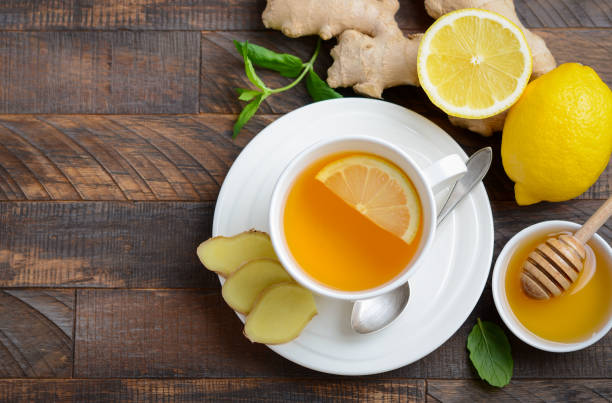 istock Ginger root tea with lemon and honey on wooden background. 1035612426