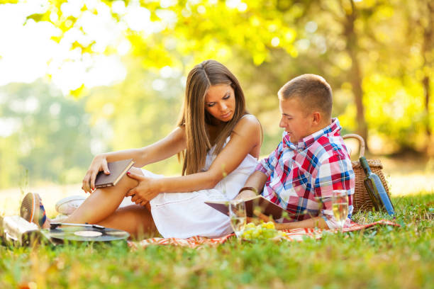 istock Couple reading a book in park 1035613608