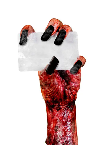 Halloween horror concept. Closeup of zombie woman hands holding a blank card, isolated on white background