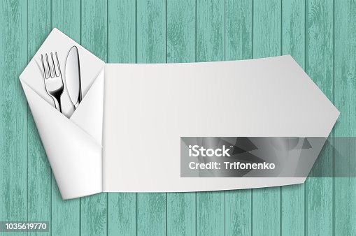 istock Fork and knife in a white napkin. Wooden table. 1035619770