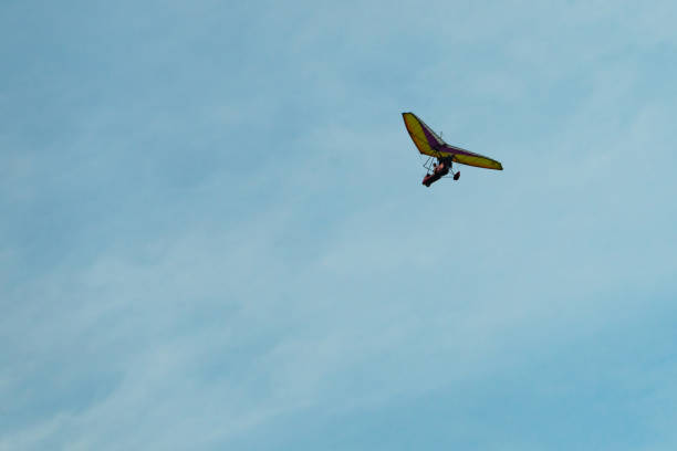 istock The hang-glider on a background blue sky with light clouds. Flying a gyroplane. 1035624386