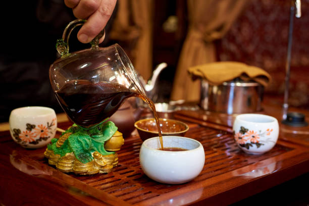 istock Tea ceremony. In a white cup the master pours tea from a glass teapot 1035624926