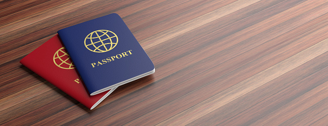 Travelling concept. Blue and red passports isolated on wooden background, banner, copy space. 3d illustration