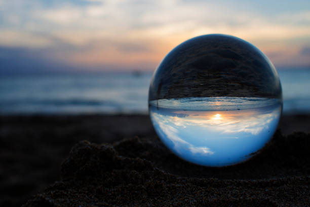 istock Sunset image on beach captured in glass ball 1035646824