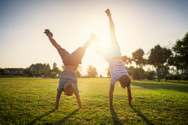 irmão e irmã de pé nas mãos na grama - acrobatic activity - fotografias e filmes do acervo