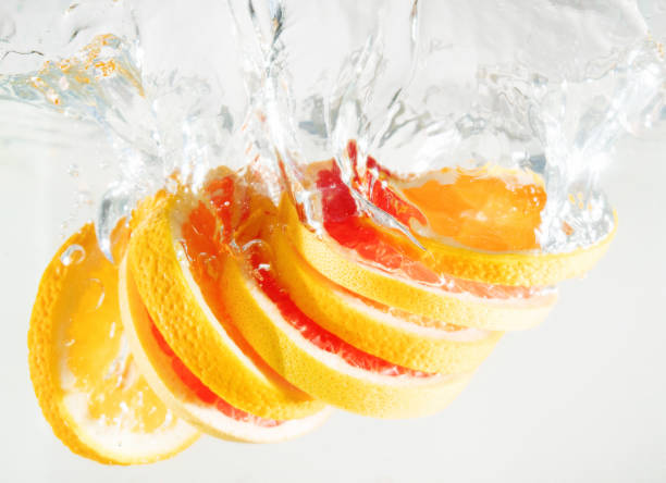 istock Grapefruit and orange falling to the water. Suitable for advertisement. 1035650496
