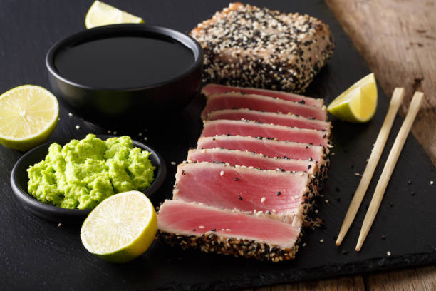 istock Stone slate tray with sliced tuna steak fried in sesame seeds. horizontal 1035653442