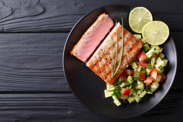 istock Freshly cooked grilled tuna steak with avocado cucumber salsa close-up. horizontal view from above 1035659110