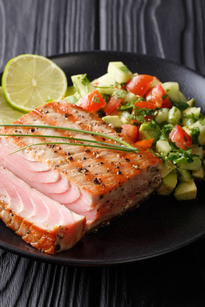istock Freshly cooked grilled tuna steak with avocado cucumber salsa close-up. vertical 1035659964