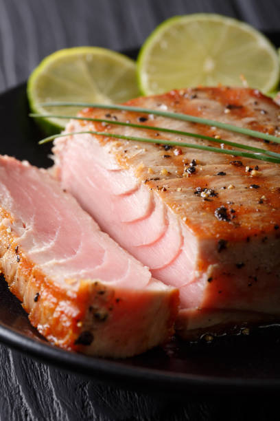istock peppers seared Tuna  steak with lime macro on a plate. vertical 1035660034