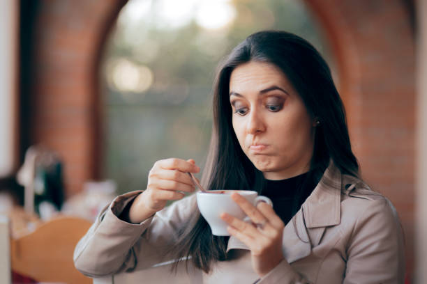 Funny Squeamish Girl with Hot Chocolate Drink Demanding client discovering caffeine intolerance awful taste stock pictures, royalty-free photos & images
