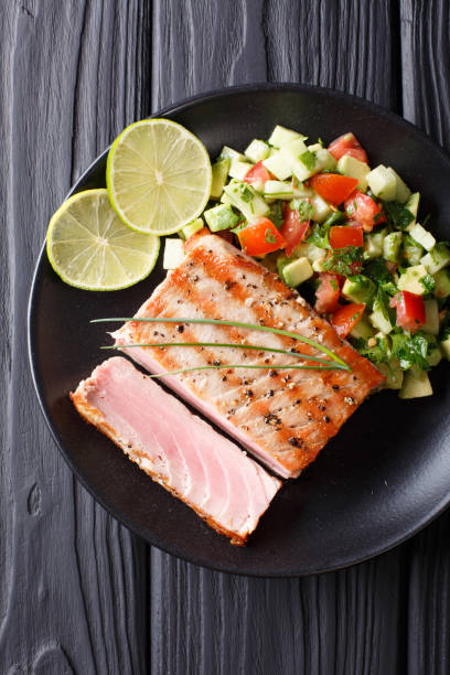 istock Mexican tuna steak with avocado cucumber salsa closeup. Vertical view from above 1035668688