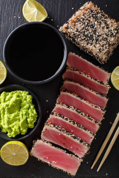 istock Sesame Seed Crusted Seared Tuna served with wasabi and sauce closeup. Top view vertical 1035668842