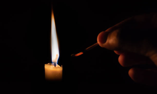 istock Person lighting a candle with a matchstick. extinguished matchstick 1035676336