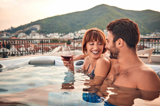 schönes paar im whirlpool bei einem glas wein genießen - vacations luxury balcony heterosexual couple stock-fotos und bilder