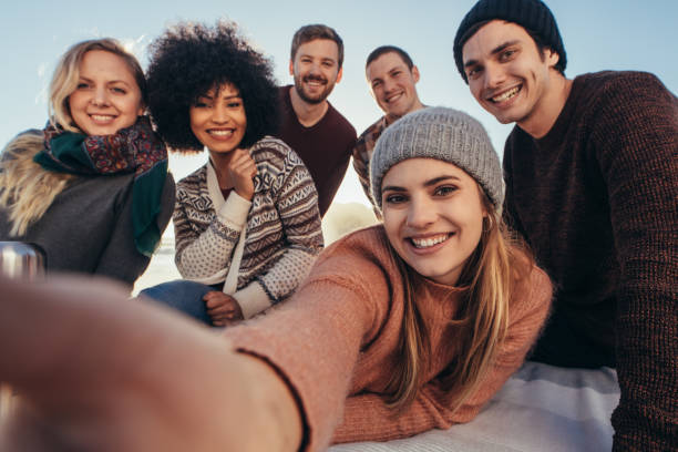 Friends taking selfie during beach party Young friends taking selfie during beach party. Group of mixed race  friends taking selfie on the seashore. picnic photos stock pictures, royalty-free photos & images