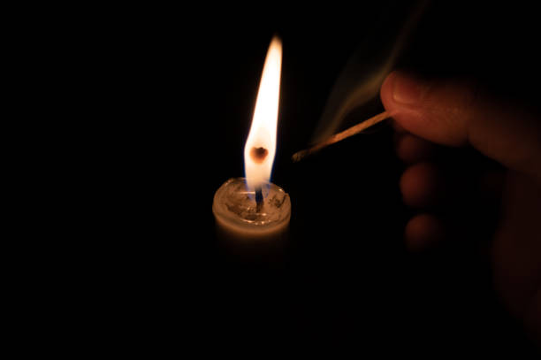 istock Person lighting a candle with a matchstick. extinguised matchstick 1035679666