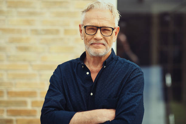 istock Senior man smiling while standing outside in his yard 1035680286