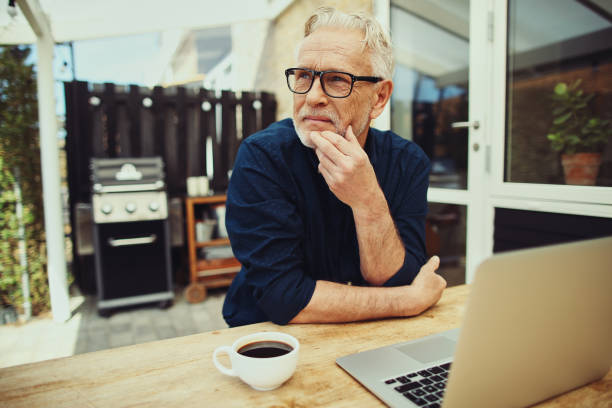 istock Senior man deep in thought with a laptop and coffee 1035681780