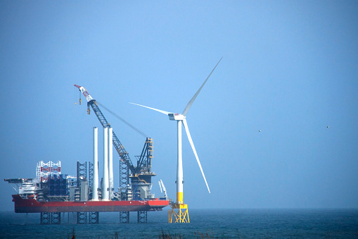 The largest wind farm installation vessel in the world and wind turbine installed off the coast of Aberdeen. Balmedie, Aberdeenshire, Scotland, UK. April 11th 2018