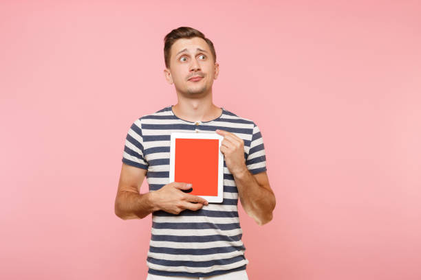 istock Portrait of young man holding tablet computer with blank black empty screen display touchscreen copy space isolated on trending pastel pink background. Technology lifestyle concept. Advertising area. 1035708578