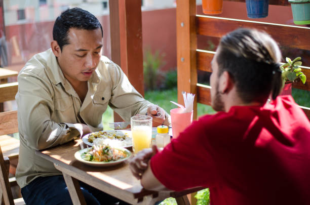 istock Good looking men having lunch in an outdoor restaurant, men chatting 1035730290