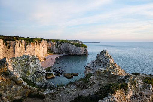 Sunset view of Etretat cliffs, lit by the last rays of the sun. Famous coastline of Cote d'Albatre (Alabaster Coast) in Normandy, France, Europe.