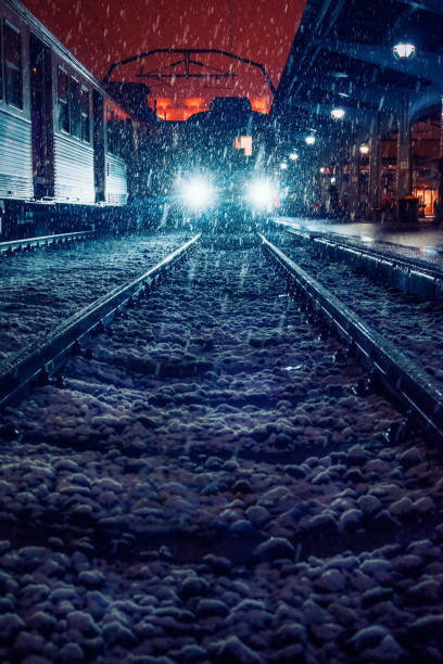 Beautiful train shot with a snow storm in the train station in the night shot in front of the train in Bucharest Nord Railroad