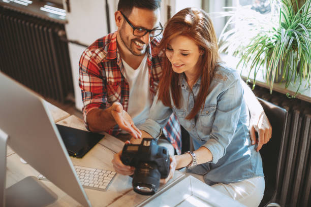 istock Young couple looking photos on the camera at home 1035744114