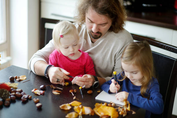 pai e seus filhos fazendo criaturas castanhas - child autumn craft preschooler - fotografias e filmes do acervo