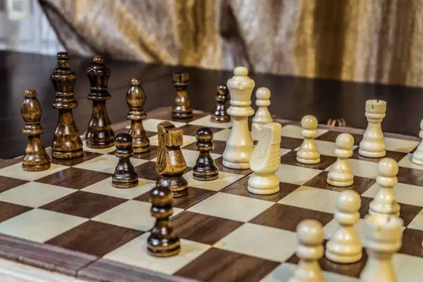 Photo of Wooden chess Board and chess pieces in in the game. Limited depth of field.