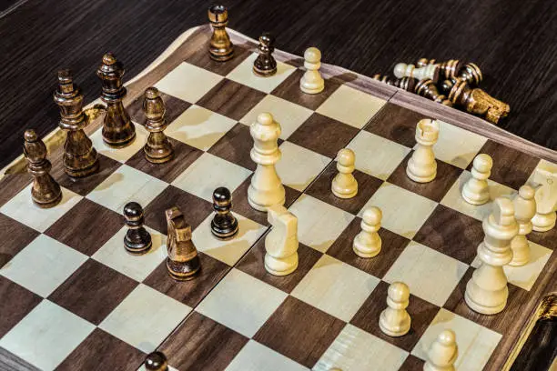 Photo of Wooden chess Board and chess pieces in in the game. Limited depth of field.