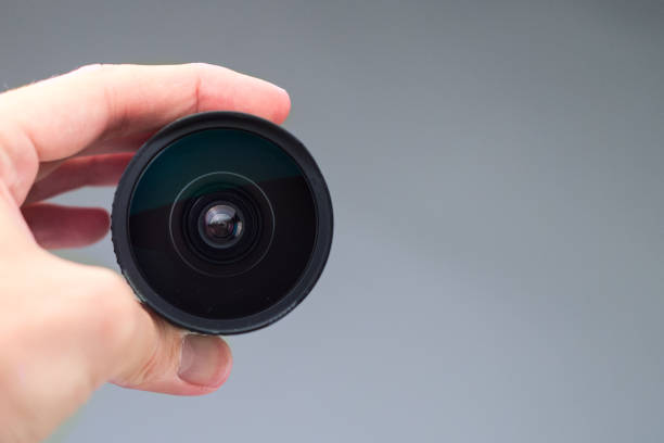 istock Old lens in hands on a white background 1035751960