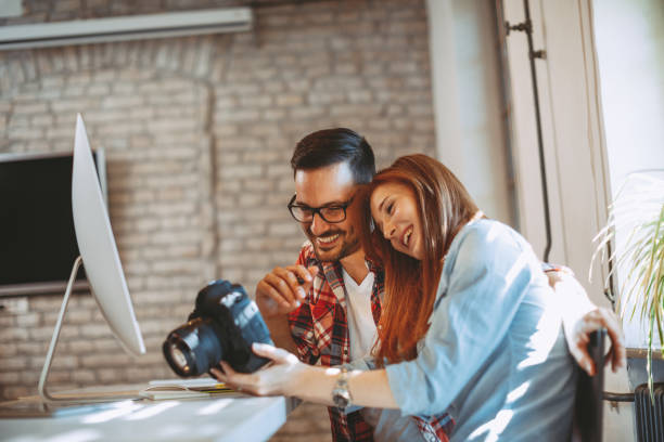istock Young couple looking photos on the camera at home 1035755090
