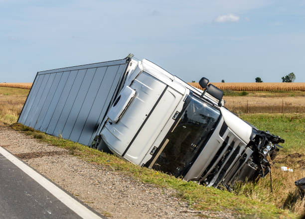 The truck lies in a side ditch after the road accident. The large truck lies in a side ditch after the road accident.  Commercial vehicles Insurance stock pictures, royalty-free photos & images