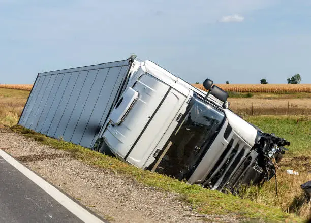 Photo of The truck lies in a side ditch after the road accident.