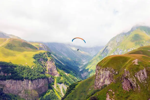 Paragliders flying with a paramotors with beautiful mountain view against blue sky