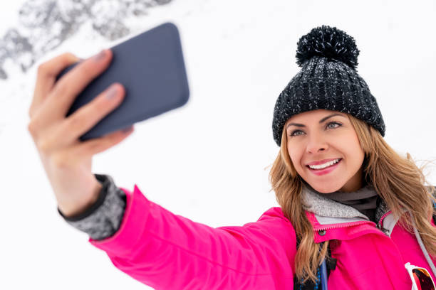 istock Happy woman taking a selfie while hiking in the snow 1035774982