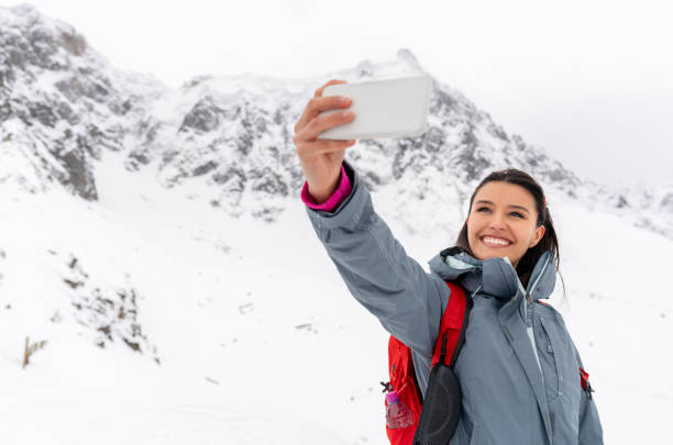 istock Happy woman taking a selfie while trekking in the snow 1035775108