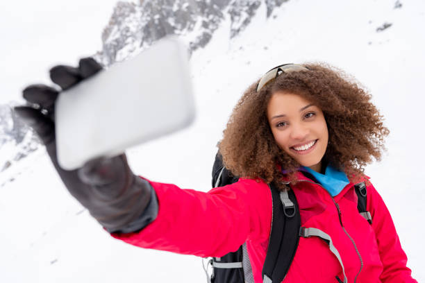 istock Happy woman taking a selfie while trekking in the snow 1035775146