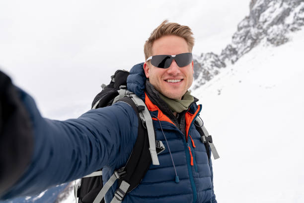 istock Happy man taking a selfie while trekking in the snow 1035775152