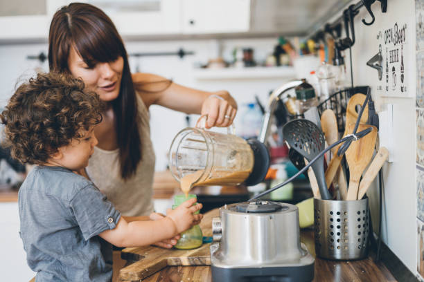 istock Mother and her little son preparing healthy smoothie 1035778318