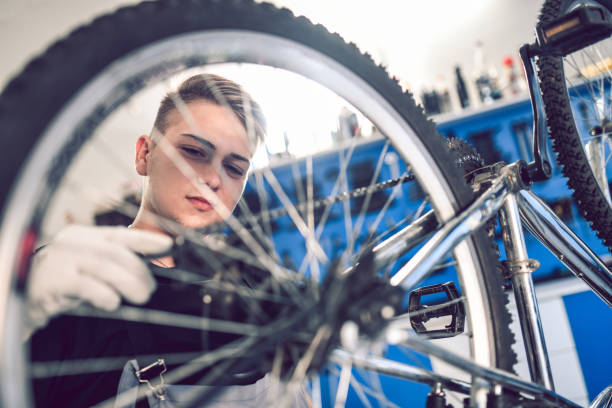 istock Young Mechanic Apprentice Fixing Bike Rear Cog 1035778714