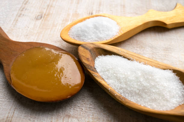 künstliche süßstoffe und zuckeraustauschstoffe in holzlöffel. natürliche und synthetische sugarfree lebensmittelzusatzstoff: sorbit, fruktose, honig, sucralose, aspartam - nahrungsmittelzusatz stock-fotos und bilder