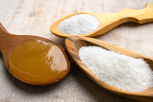 Artificial Sweeteners and Sugar Substitutes in wooden spoons. Natural and synthetic sugarfree food additive:  sorbitol, fructose, honey, Sucralose, Aspartame