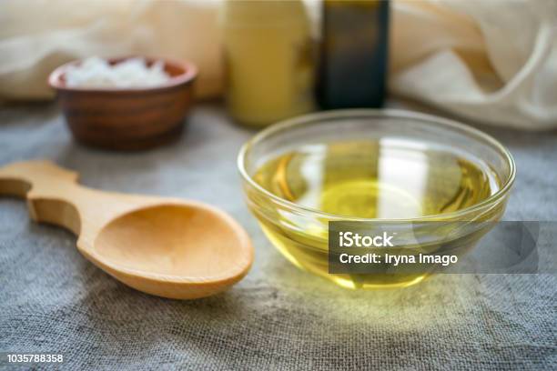 Liquid Coconut Mct Oil In Round Glass Bowl With Wooden Spoon And Bottles Health Benefits Of Mct Oil Triglycerides A Form Of Saturated Fatty Acid Stock Photo - Download Image Now