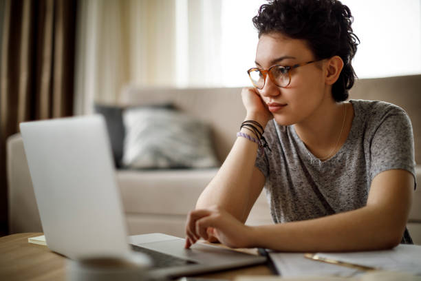 jovem mulher trabalhando em casa  - child computer internet laptop - fotografias e filmes do acervo