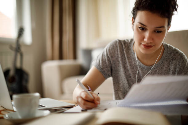 joven mujer trabajando en su casa  - finance reading and writing learning business fotografías e imágenes de stock