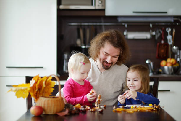 pai e seus filhos fazendo criaturas castanhas - child autumn craft preschooler - fotografias e filmes do acervo