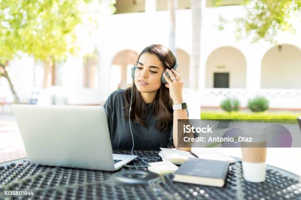 Freelancer Using Headphones And Laptop At Table In Garden Stock Photo - Download Image Now